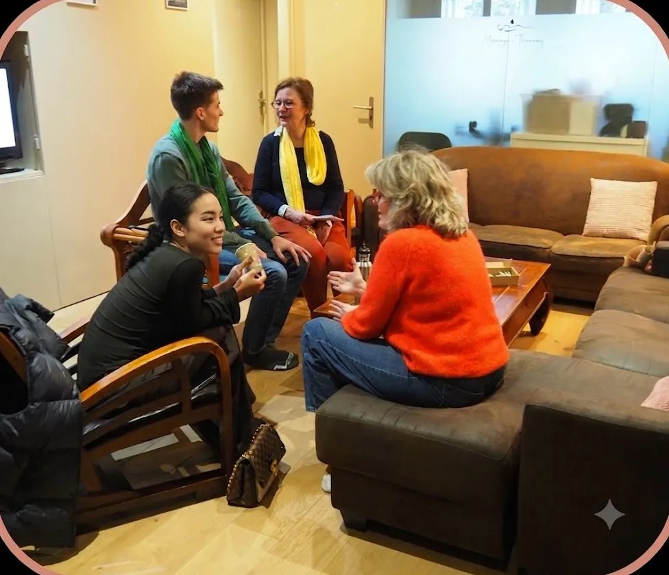 Quatre personnes discutent, assises dans le salon de l’école