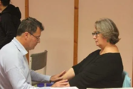 Séance de kinésiologie : un praticien pose la main sur l’avant-bras tendu d’une femme pour un test musculaire