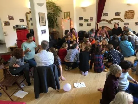 Stage de supervision : une vingtaine de praticiens assis en cercle sur le parquet d’une grande salle échangent en petits groupes